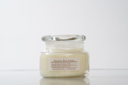 Glass jar scented candle labeled Banana Nut Bread